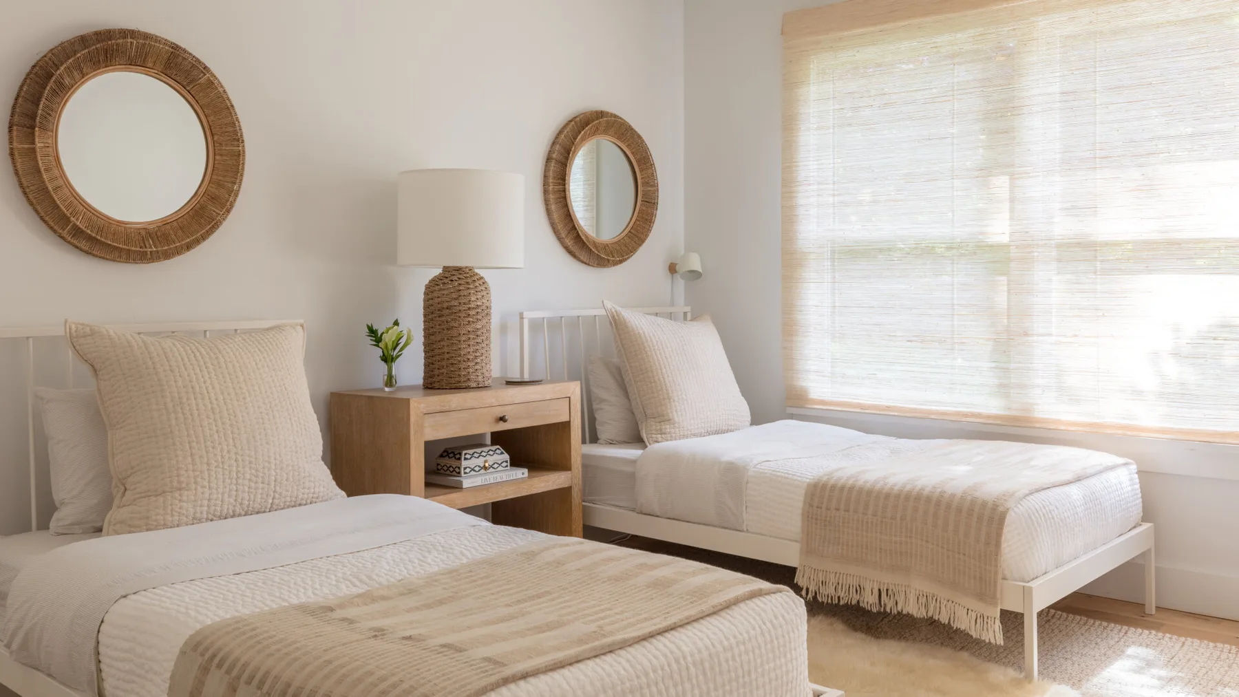 Un dormitorio luminoso con dos camas y una ventana soleada.