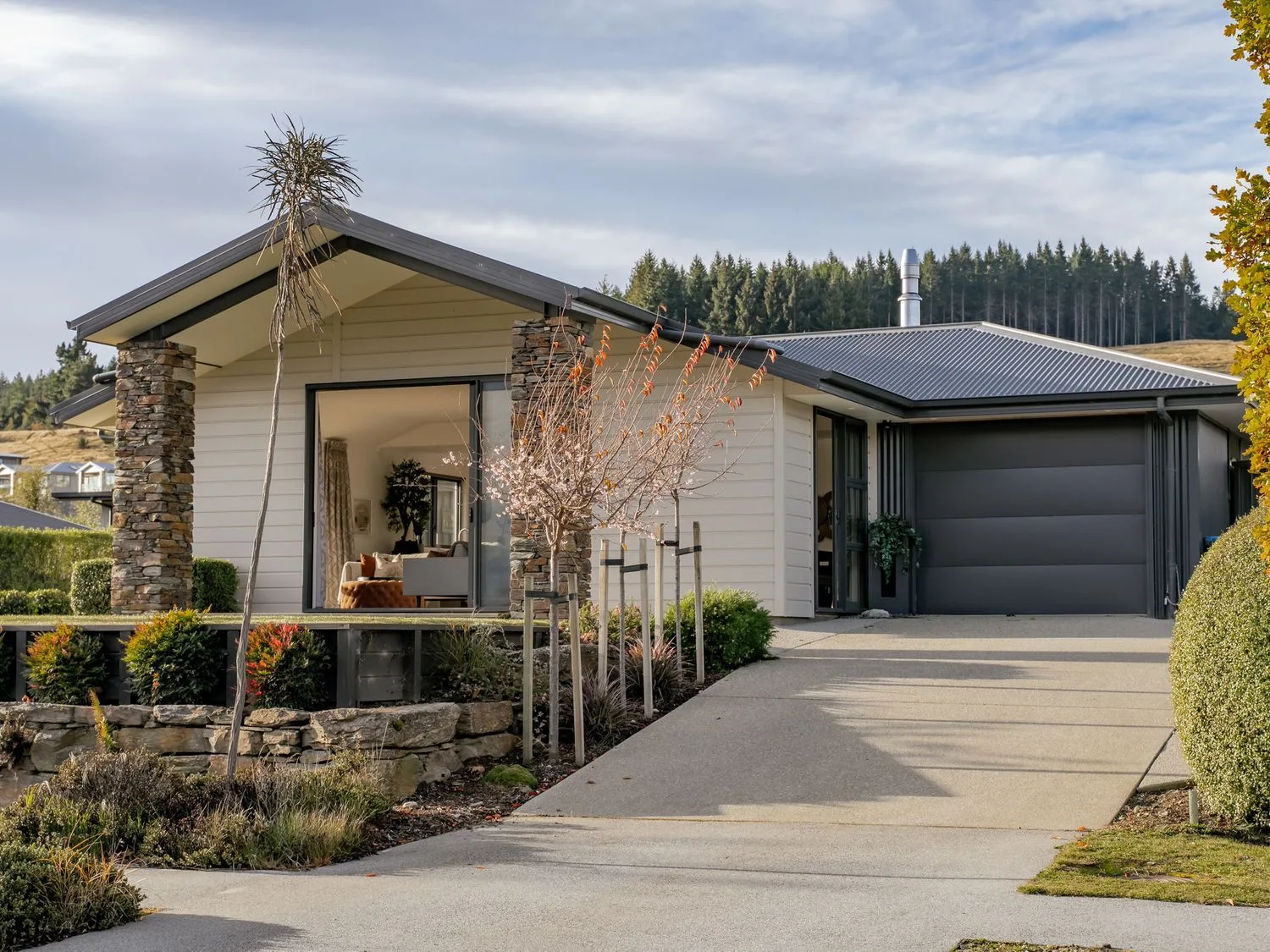 A house with a garage and garden at Mako Haven - Mountain Outlook Wanaka