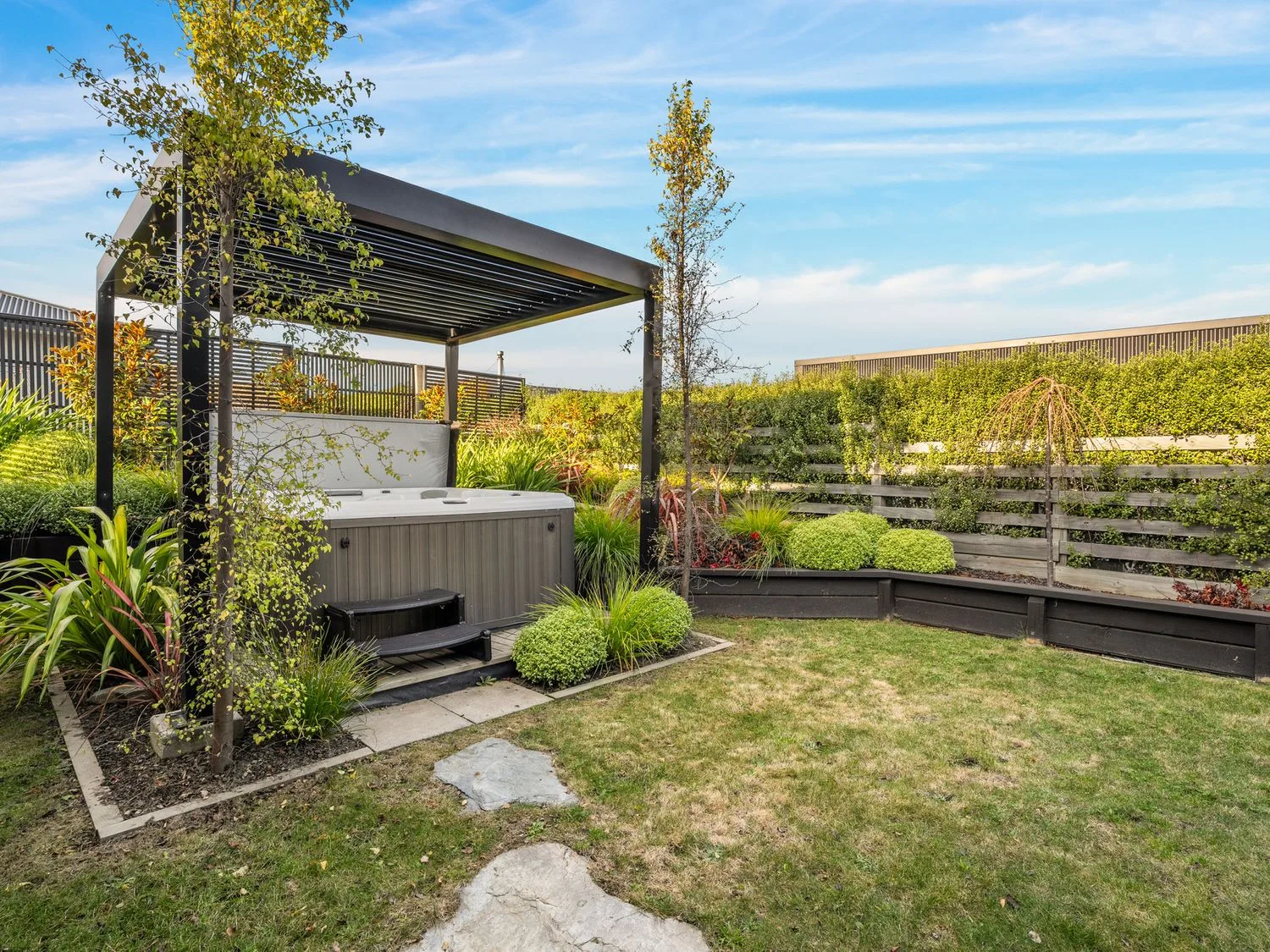 Un jardín con una bañera de hidromasaje y plantas en Mako Haven - Mountain Outlook, en Wanaka