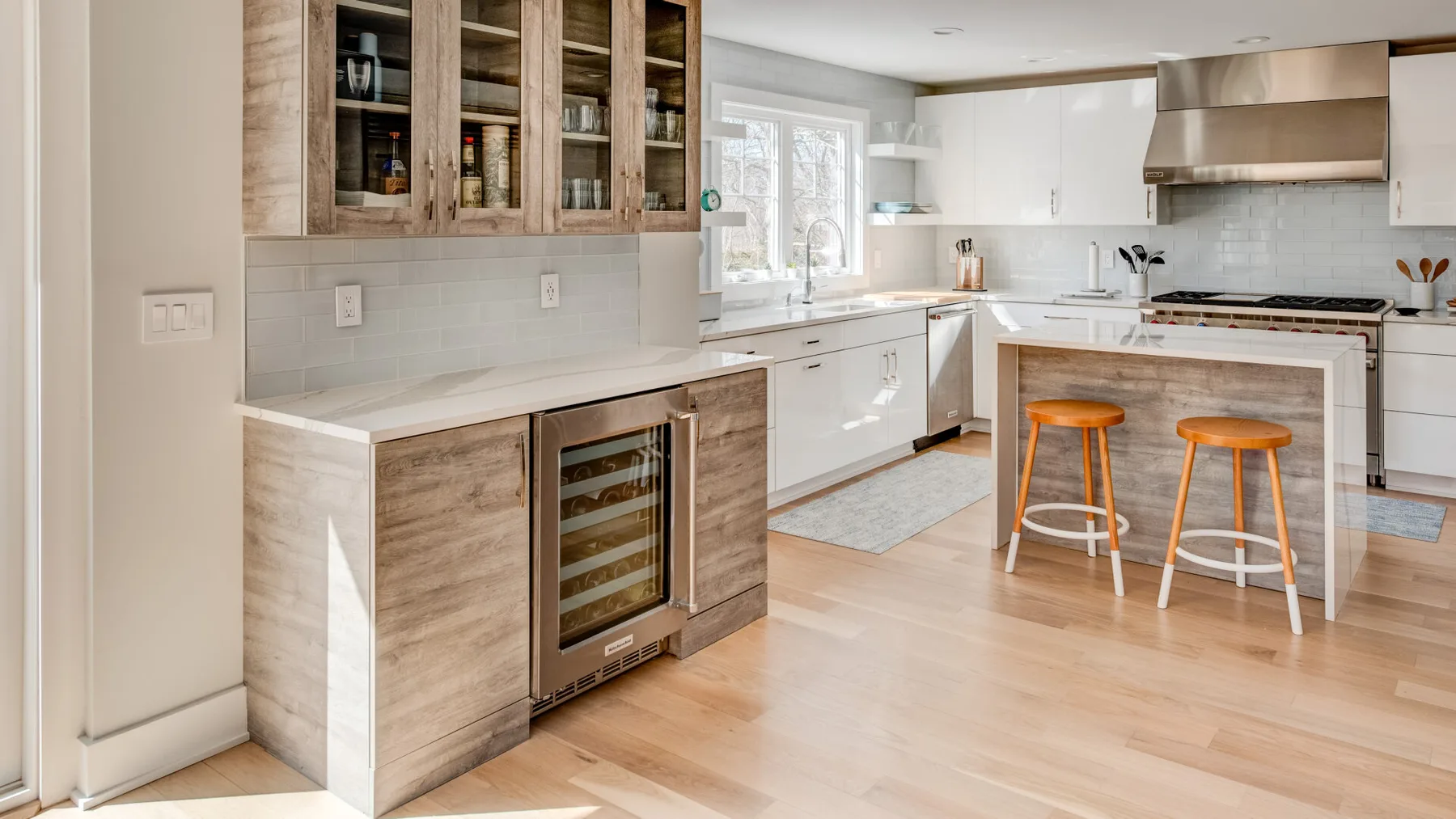 Una cocina moderna y luminosa con una isla central y taburetes de madera.