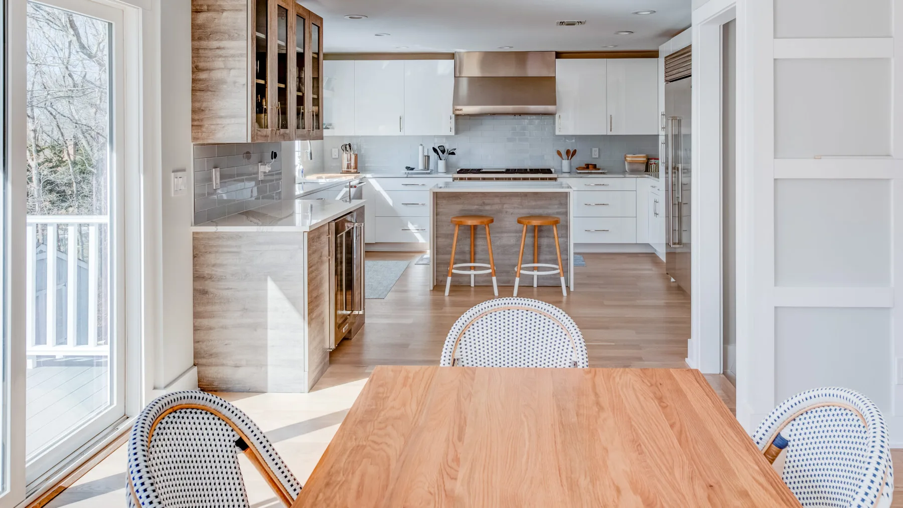 Una cocina luminosa y comedor con una mesa de madera en primer plano.