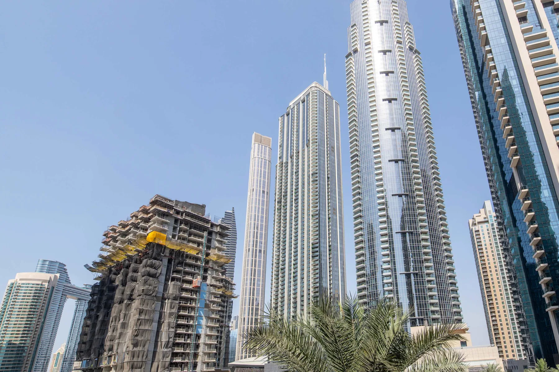 Un perfil urbano con altas torres de vidrio y un edificio en construcción.