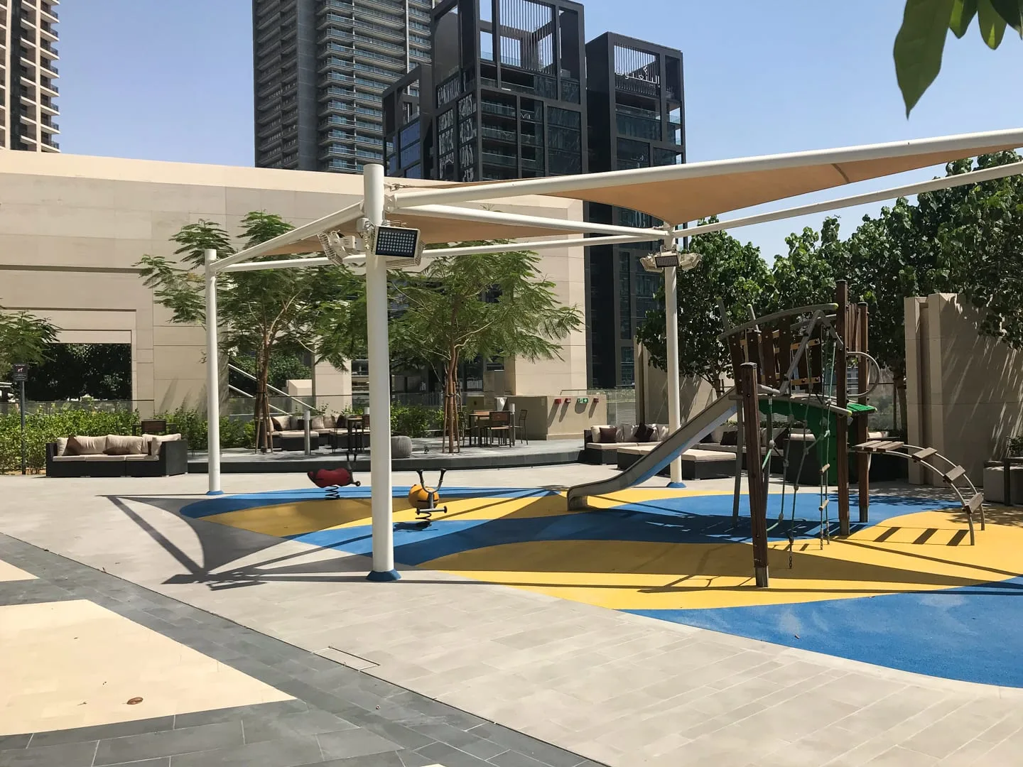 Un parque infantil al aire libre con suelo de colores y estructuras para trepar.