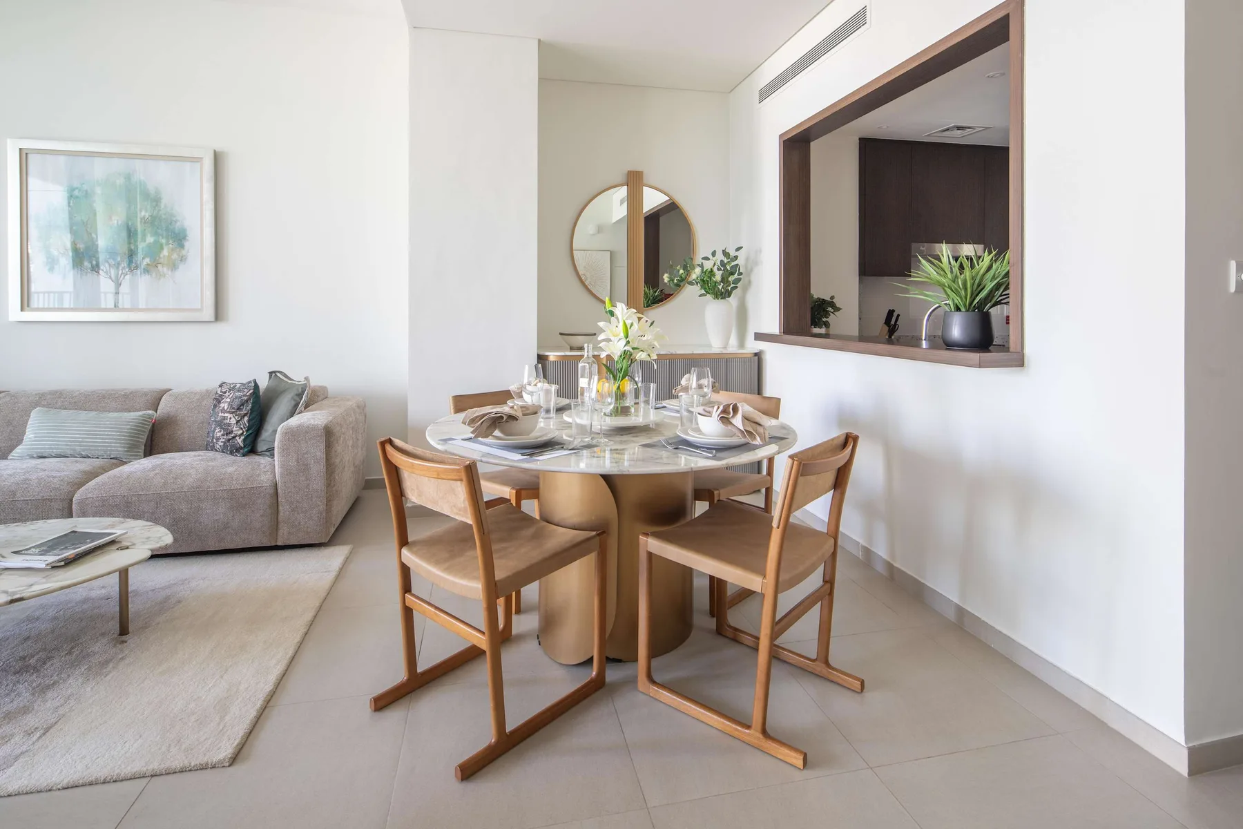 Comedor con la mesa puesta y asientos junto a una sala de estar.