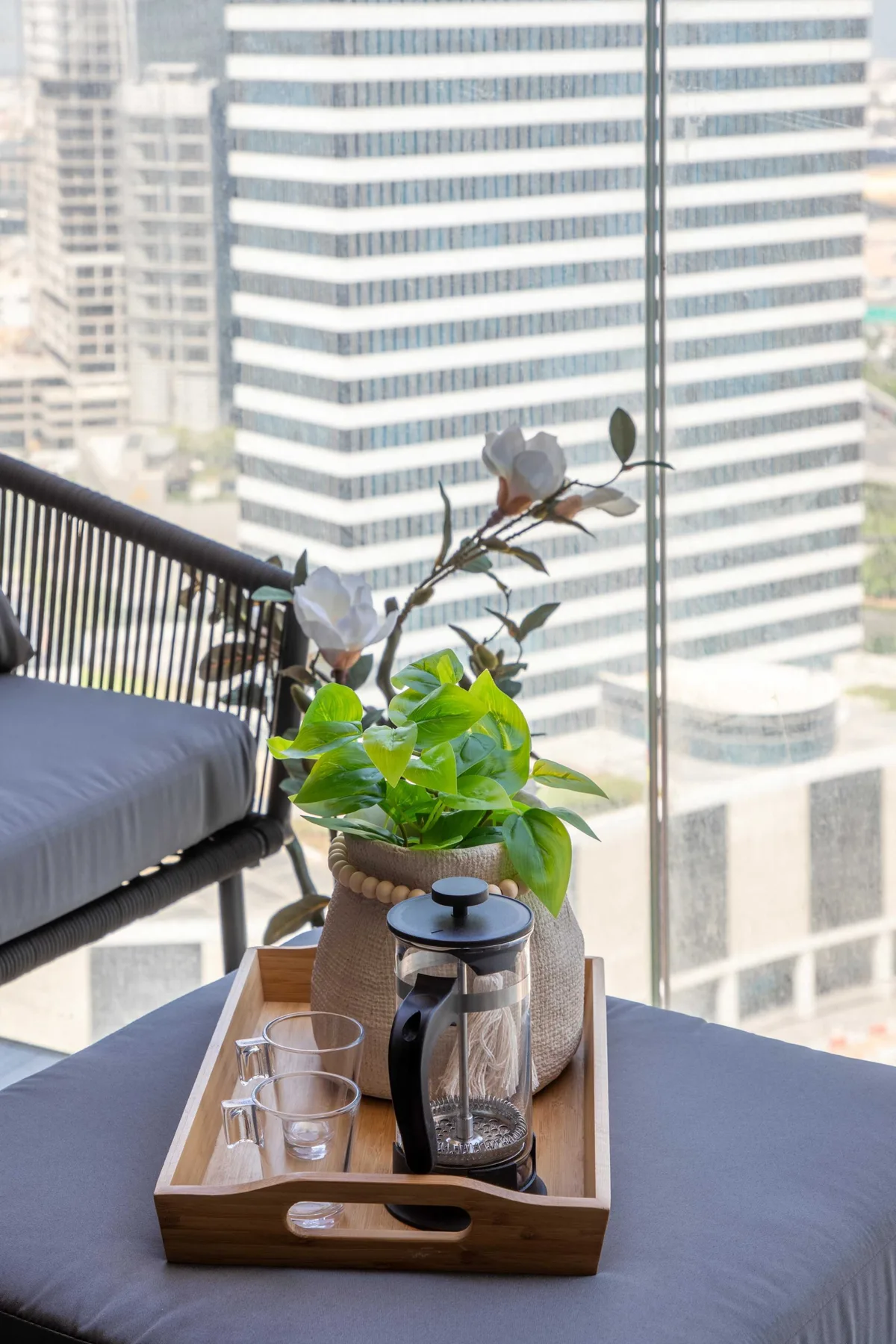 Una zona de descanso junto a una ventana tiene vistas a edificios de oficinas.