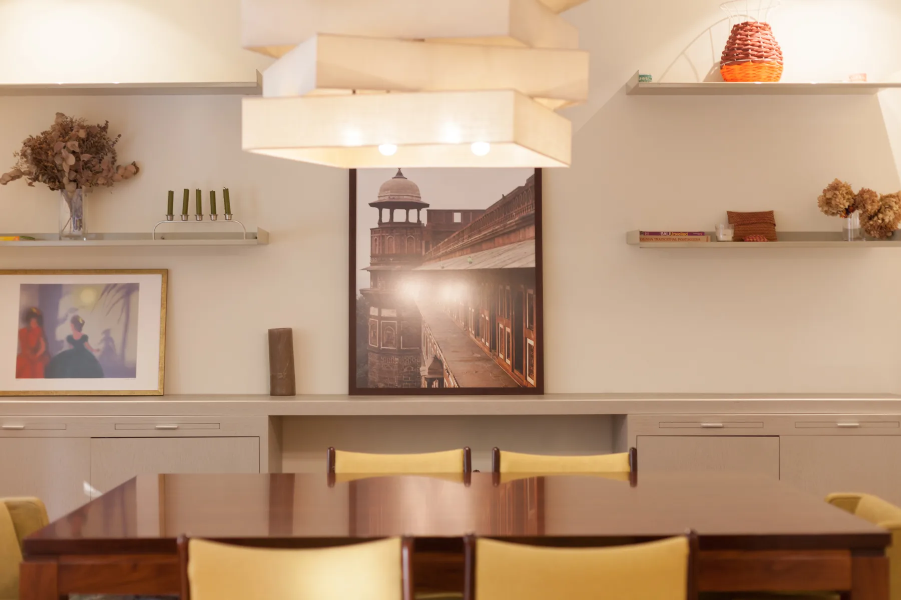 Comedor con una mesa larga de madera y cuadros en la pared.