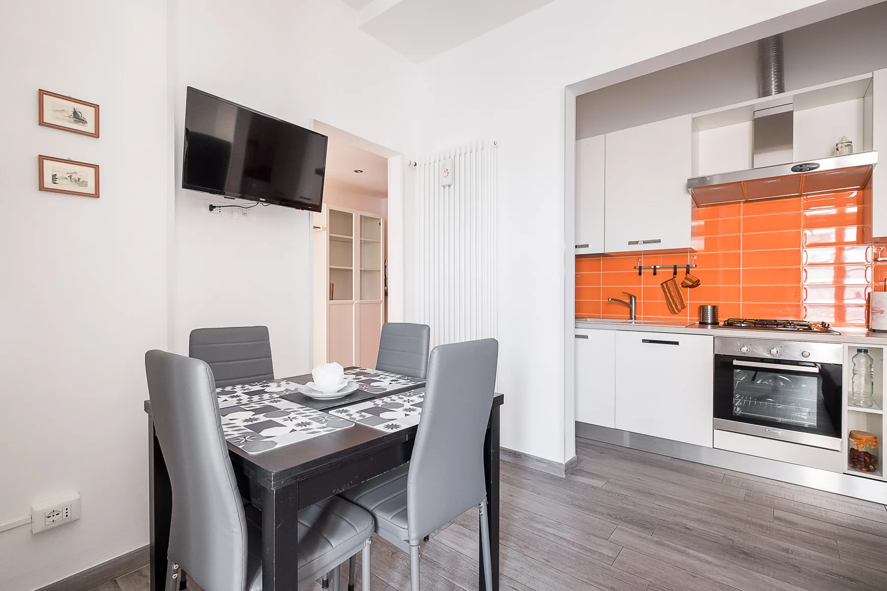 A dining area with a table and chairs beside an open kitchen.