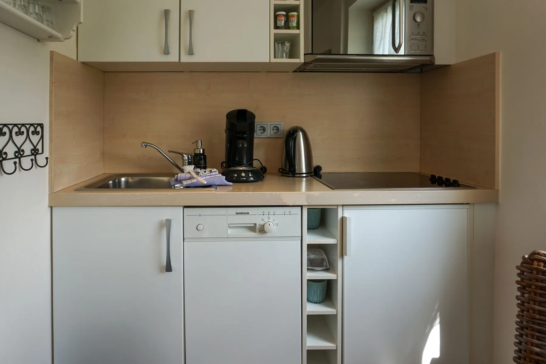 A compact kitchen with a sink, cooktop, and small appliances.