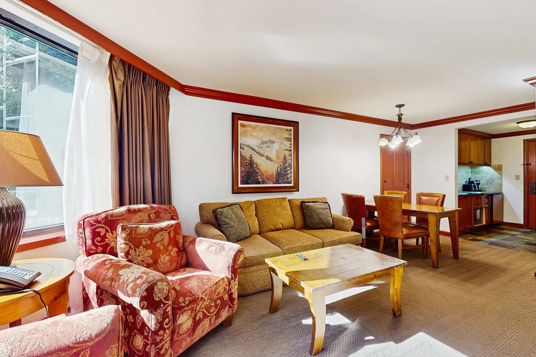 A living room with seating, a coffee table, and a dining area.