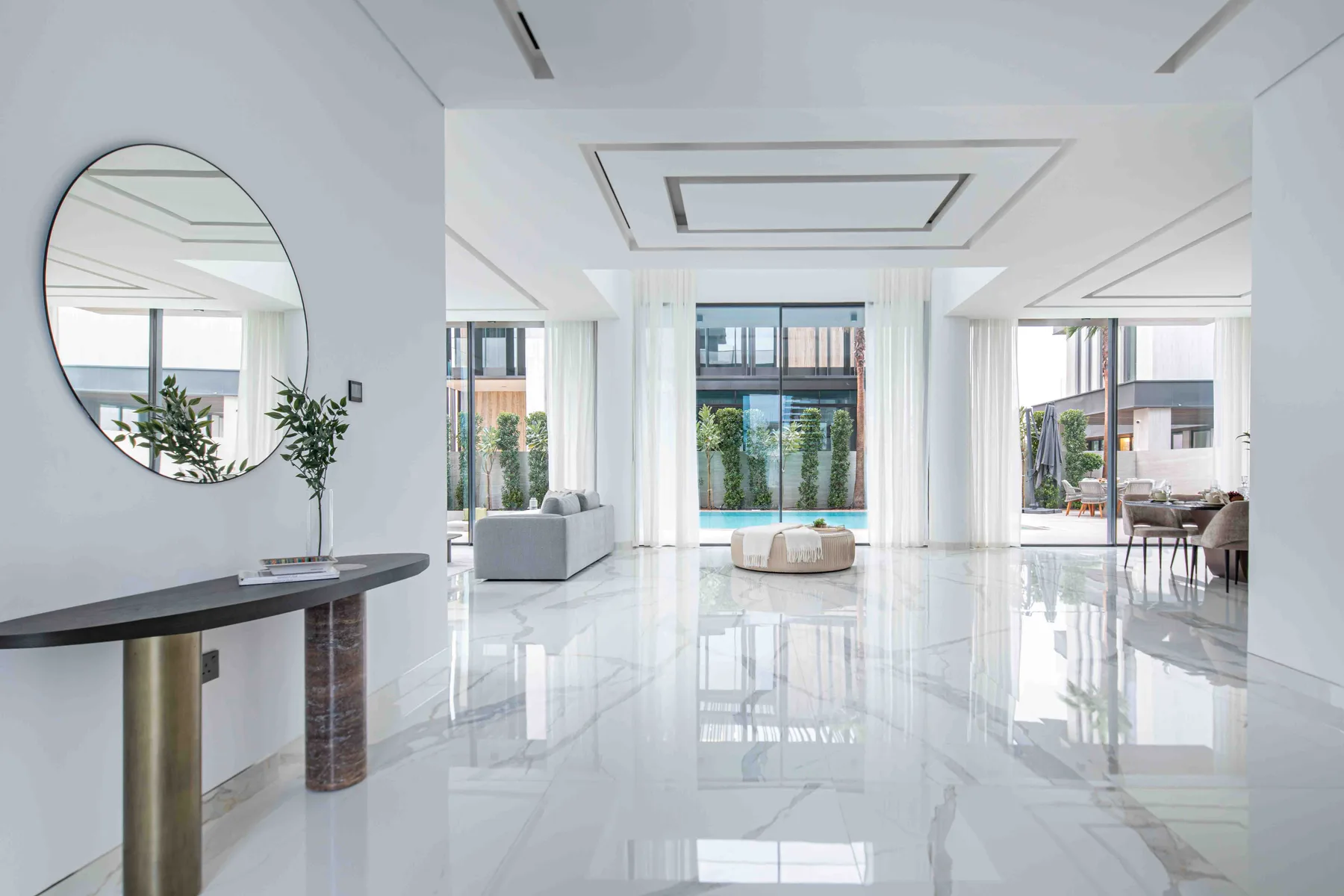Luminoso salón moderno con ventanales de suelo a techo y una zona de estar.