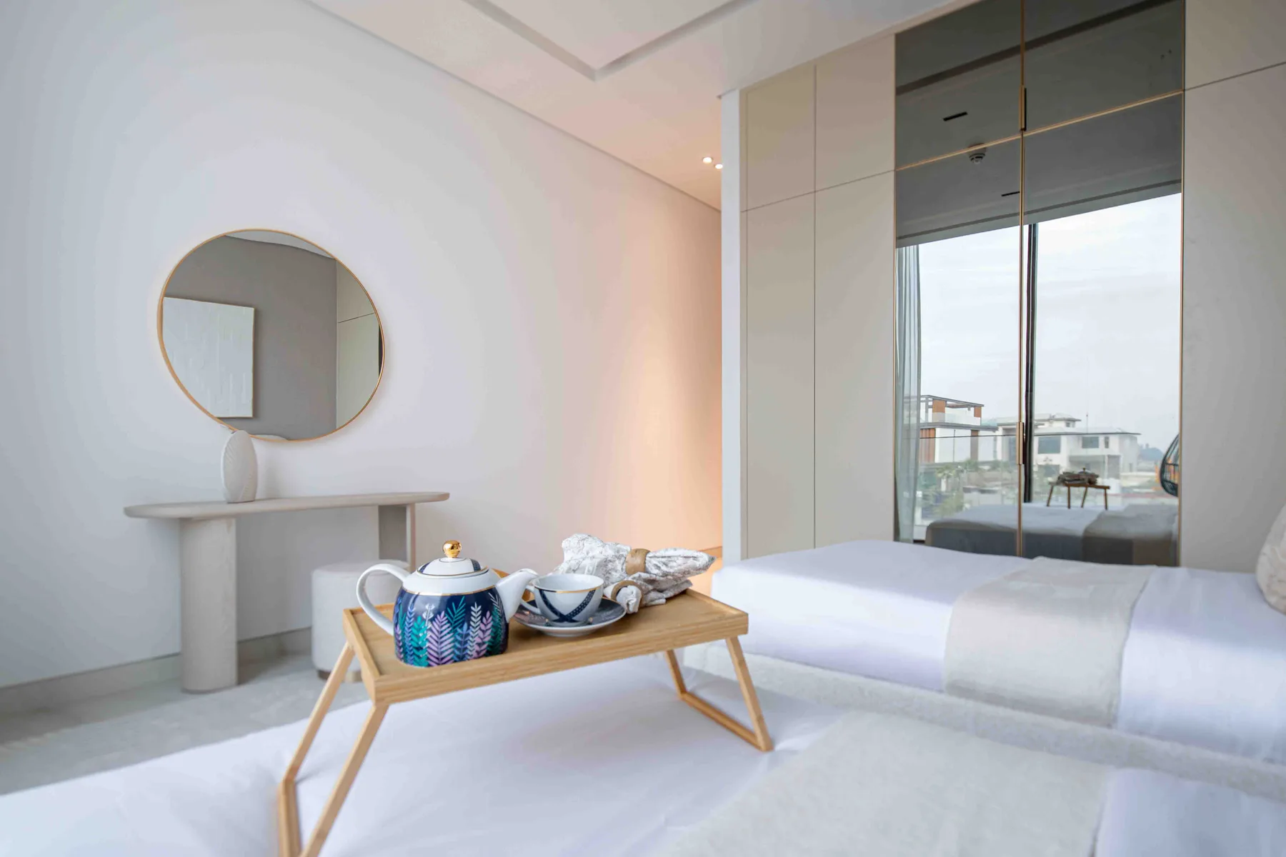 Un dormitorio luminoso con una cama baja y una pequeña mesa de té delante.