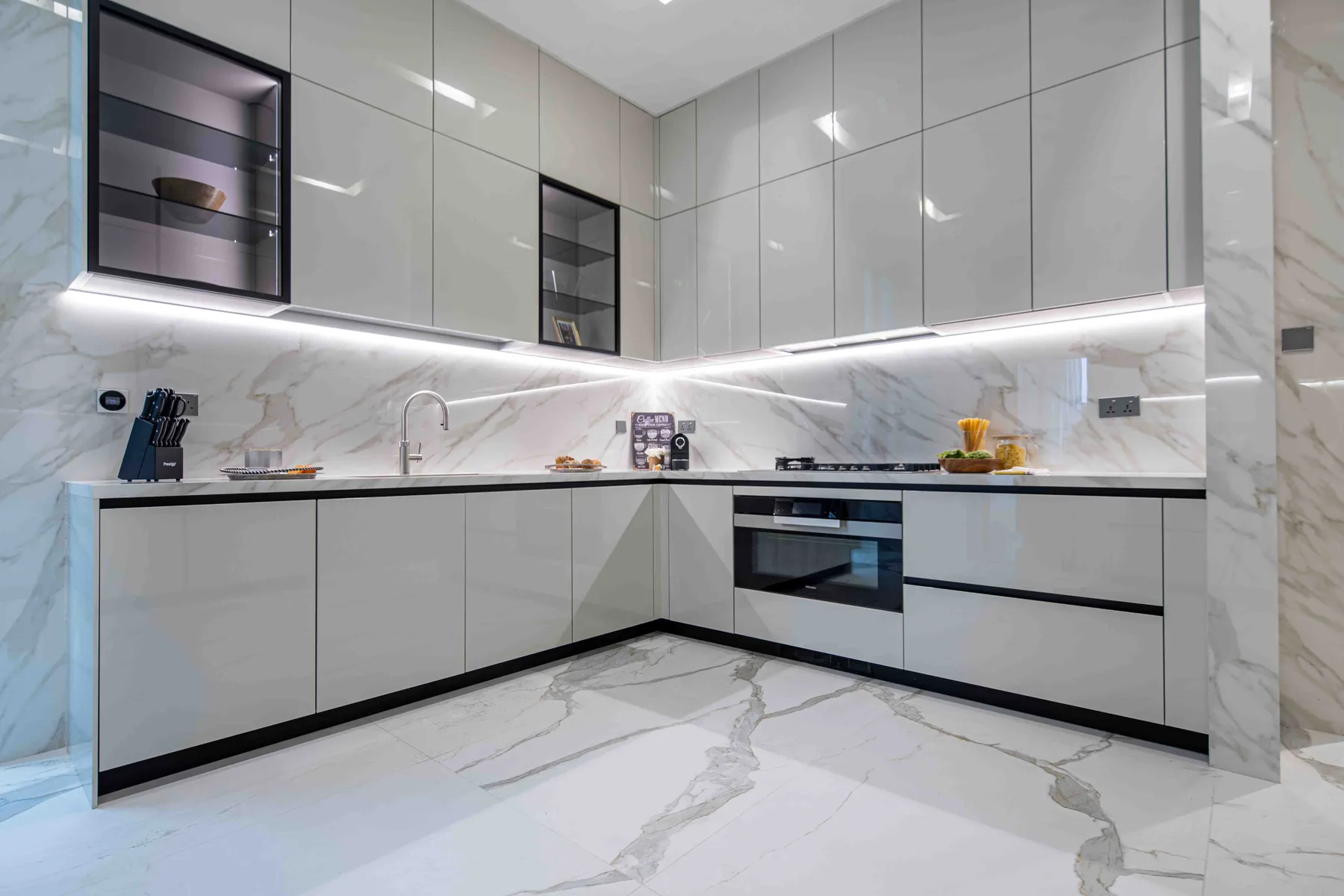 Una cocina moderna con gabinetes brillantes, una encimera y un horno integrado.