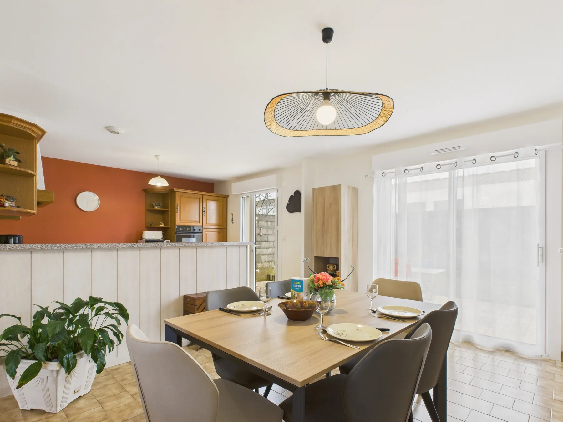 A dining area with a wooden table beside a bright window.