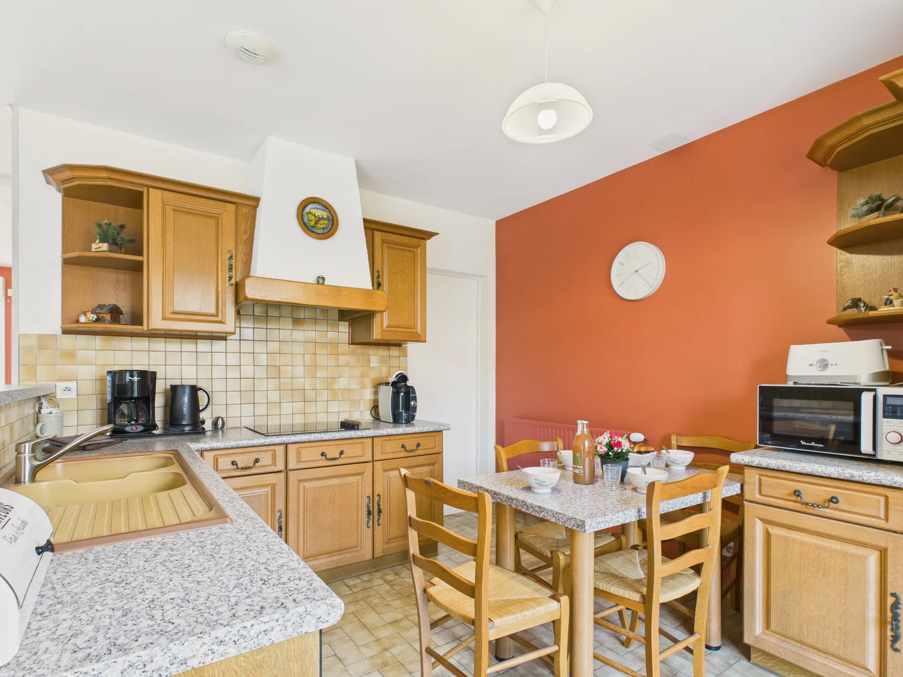A kitchen and dining area with wooden cabinets and a table.