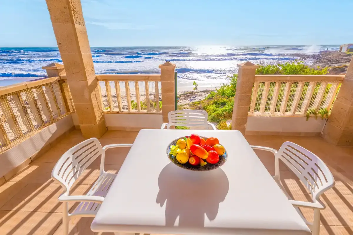 Una mesa de comedor al aire libre con un frutero da al océano.