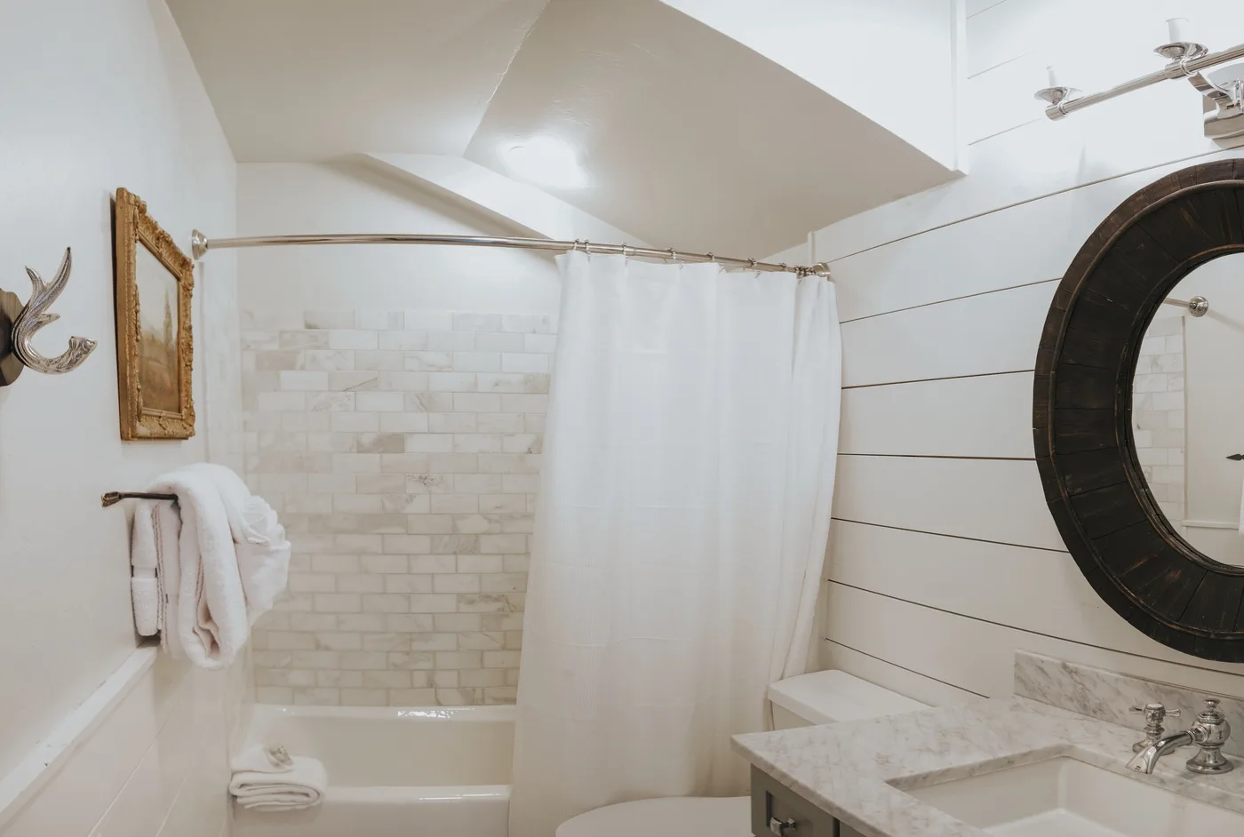 A bathroom with a bathtub, shower curtain, and sink.