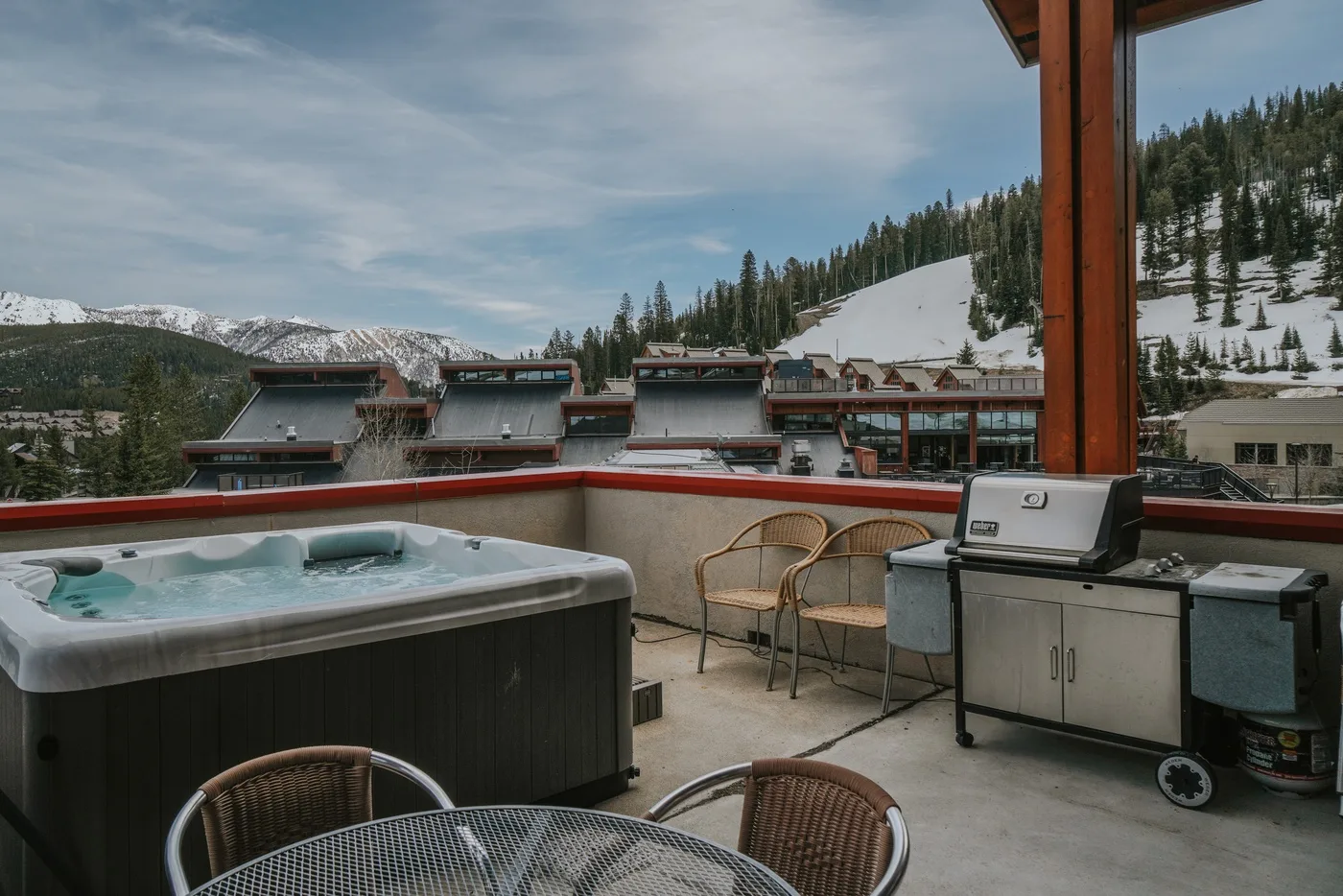 A rooftop terrace with a hot tub, seating, and a mountain view.
