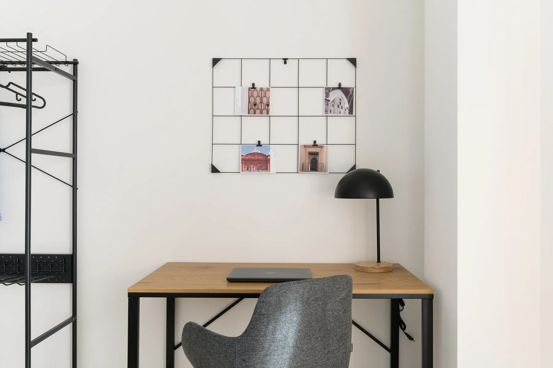 Un escritorio y una silla están bajo una exhibición de pared, con una lámpara sobre el escritorio.