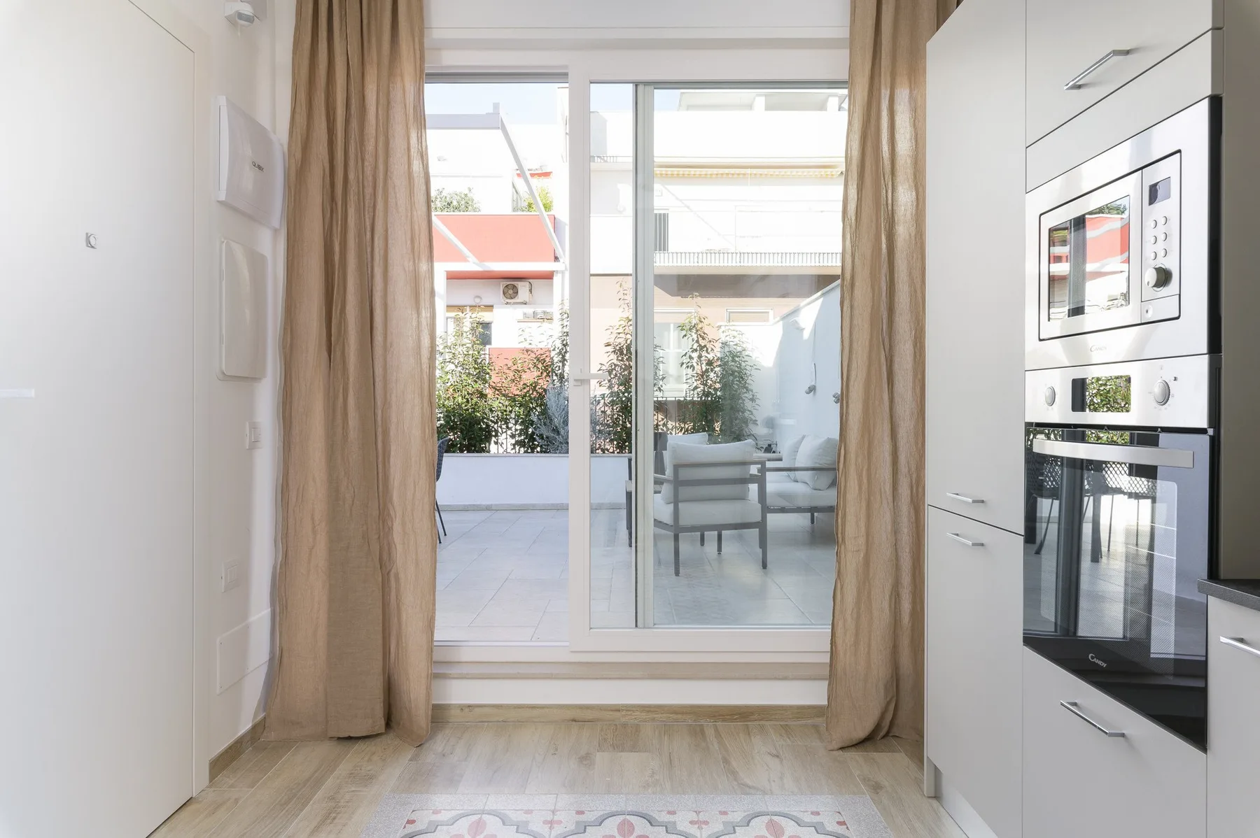 Una cocina luminosa da a un patio a través de grandes puertas de vidrio.