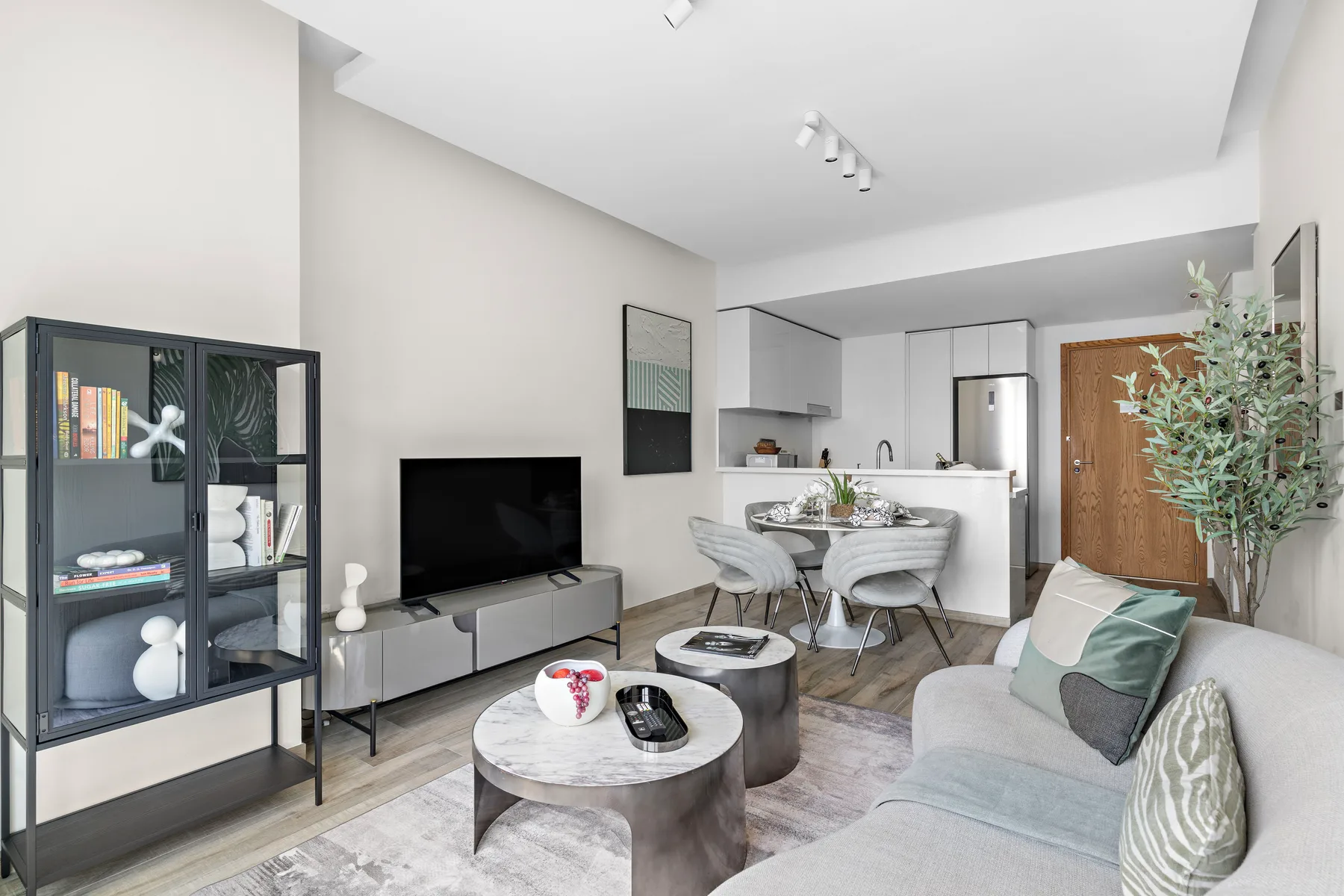 A bright living room opens onto a dining area and compact kitchen.