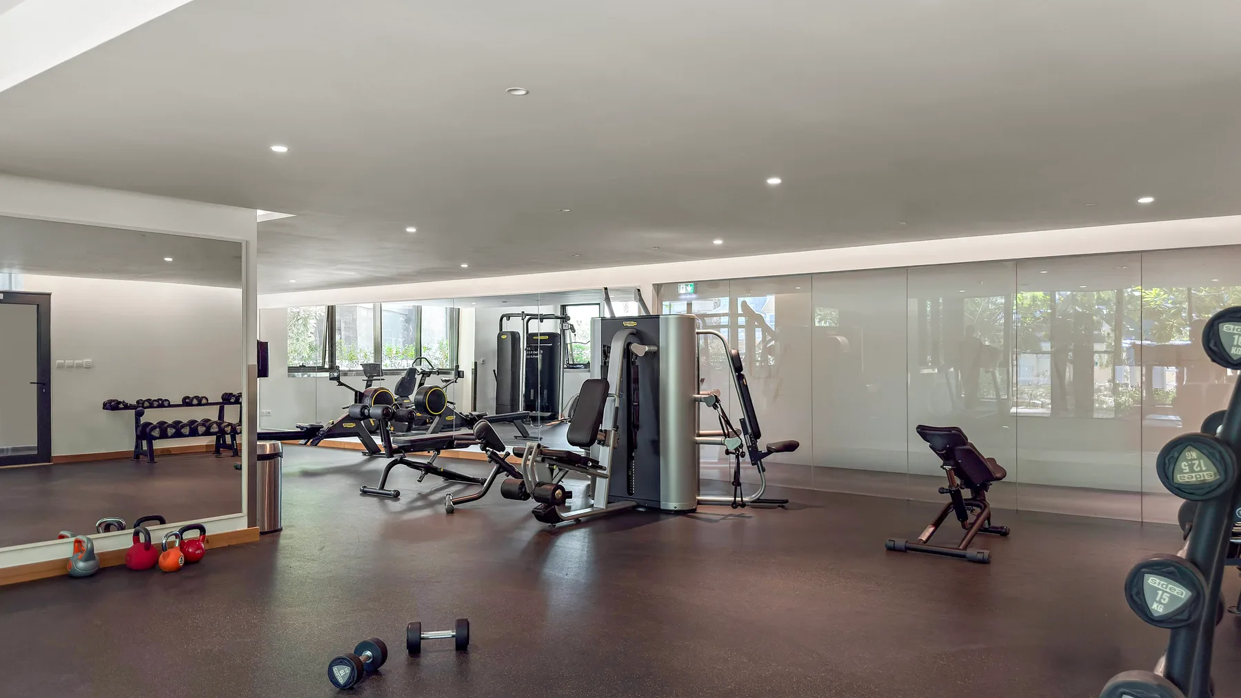 A fitness room with exercise machines and weights.