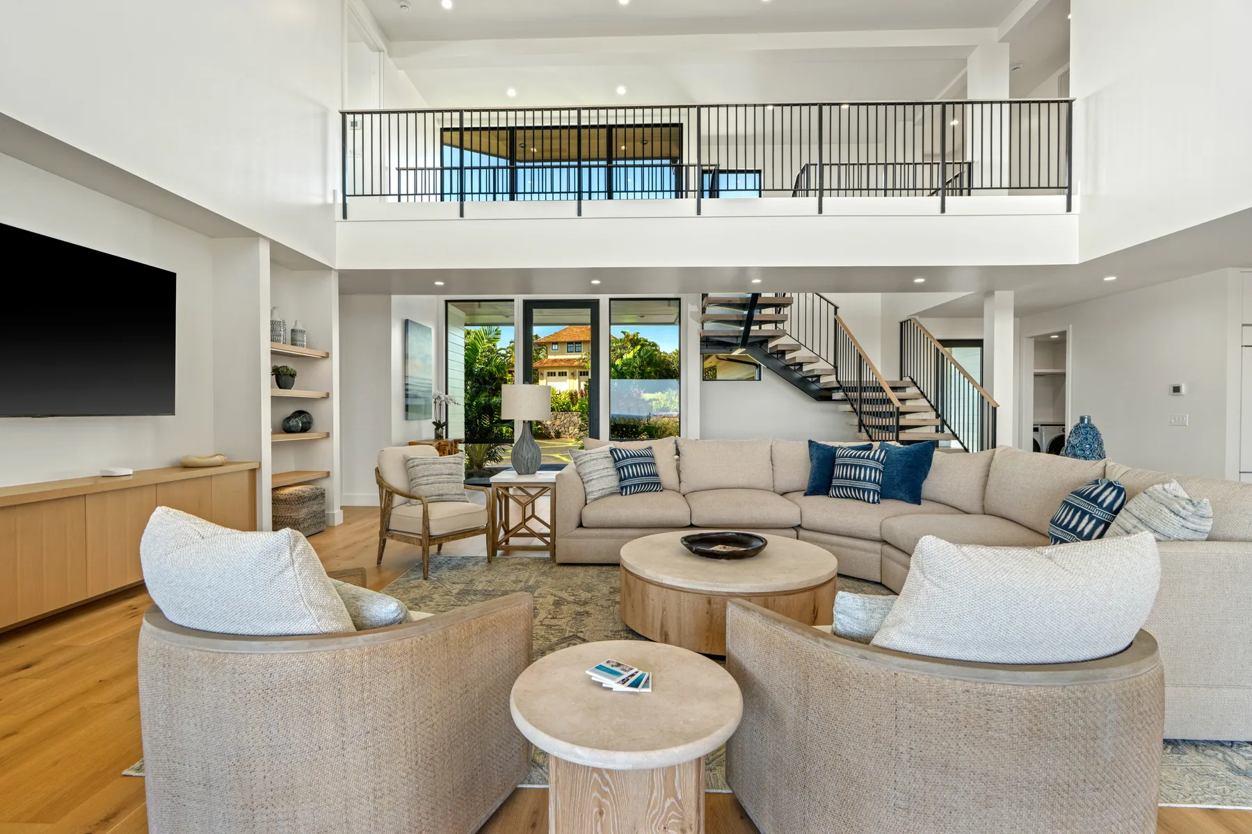A bright open-plan living room with seating arranged around a coffee table.