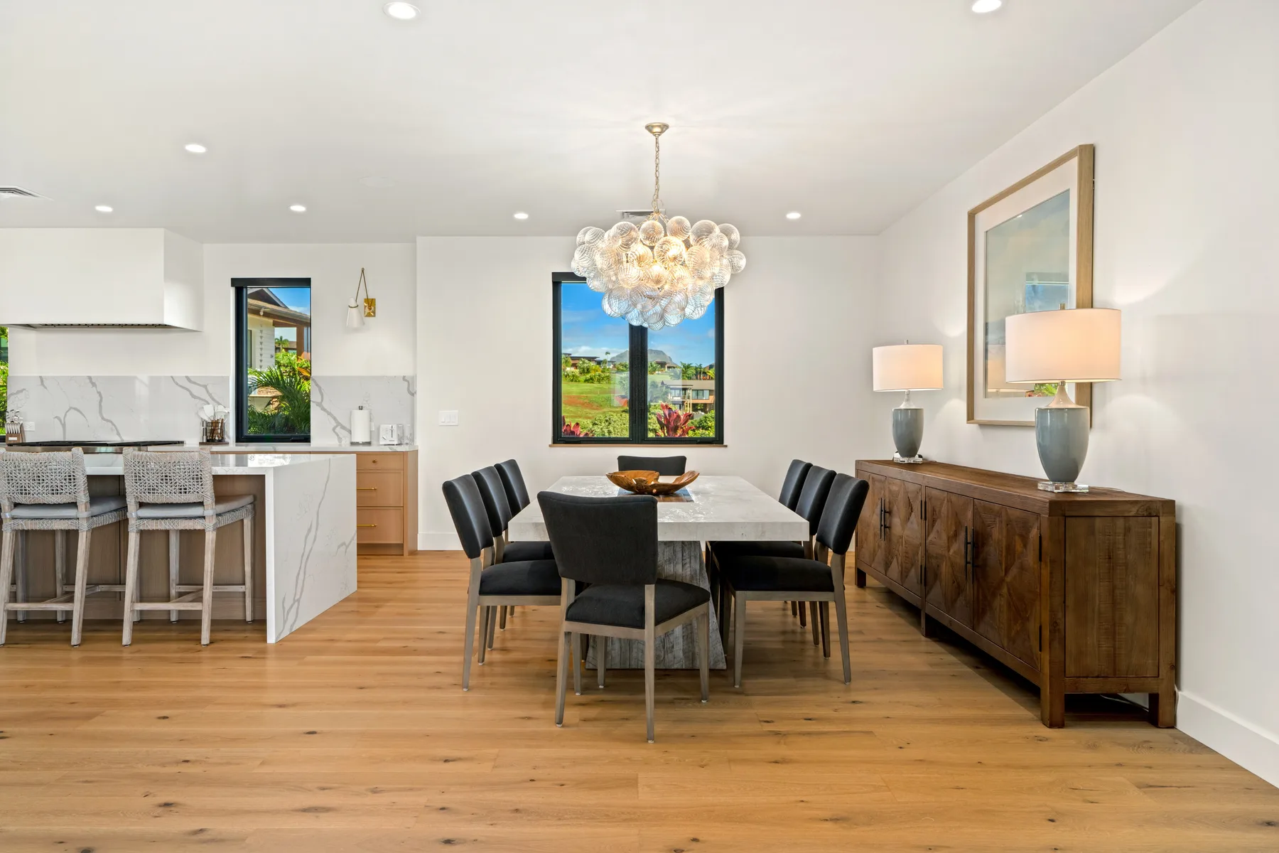 A dining area with a table, seating, and a wooden sideboard.