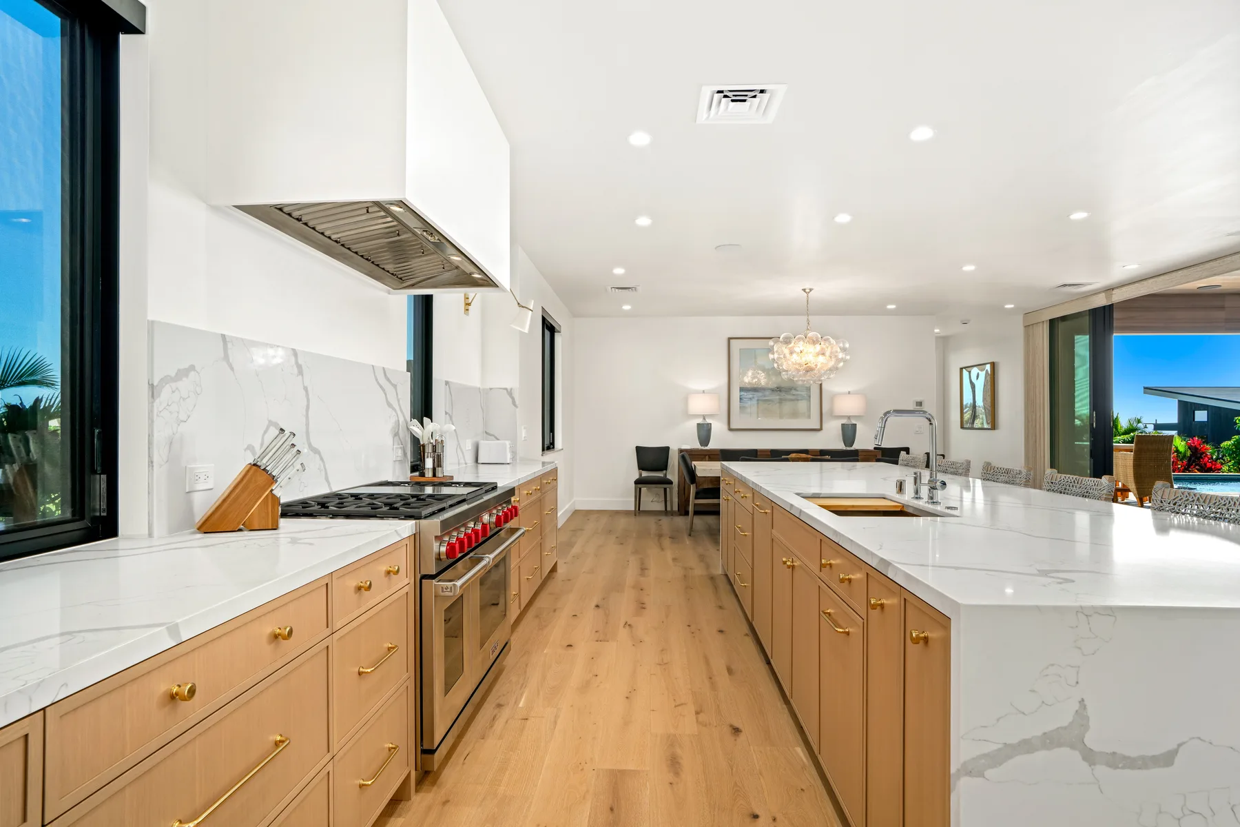 A bright kitchen with a central island and a dining area beyond.