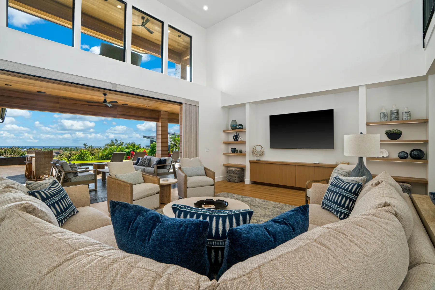 A bright living room with a large seating area and an open view to the patio.