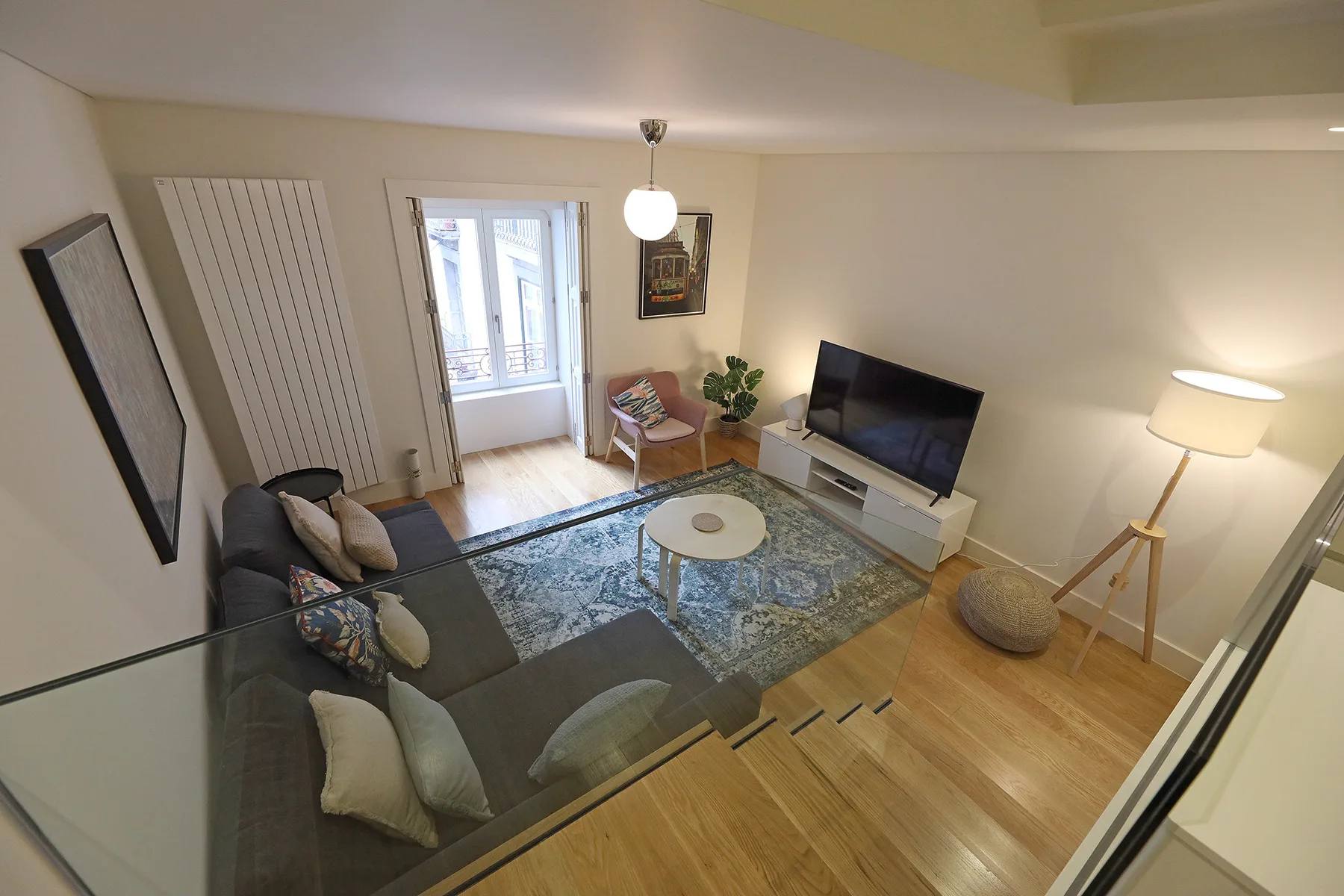 Living room with seating, a television, and a patterned rug.