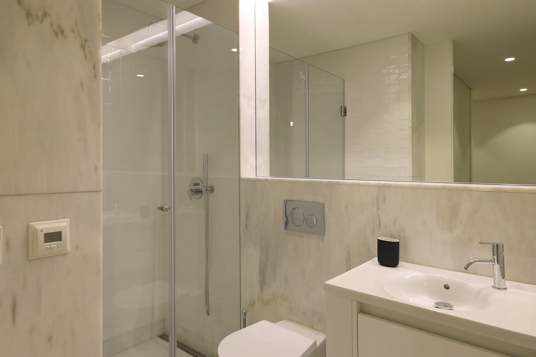 A bright bathroom with a glass shower and a white vanity.