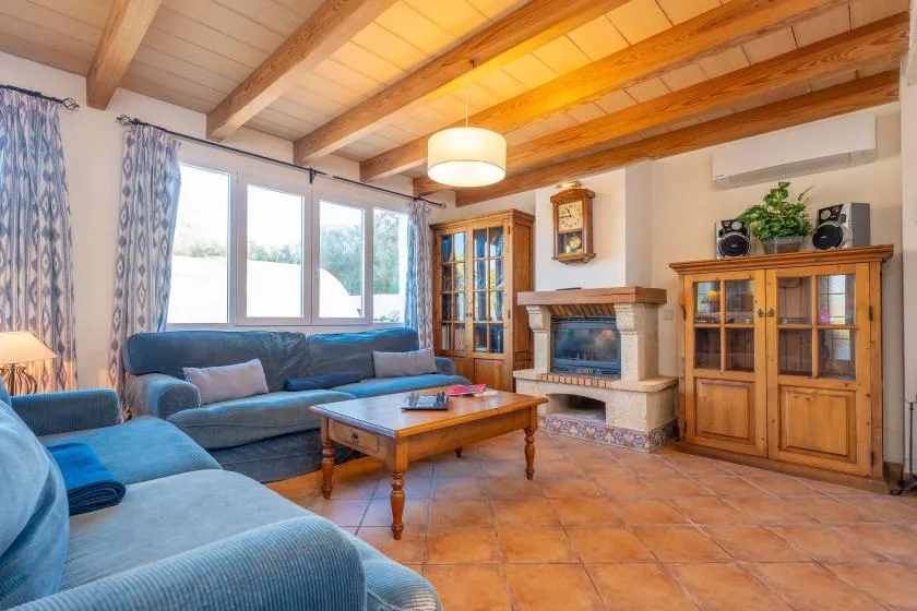 A living room with blue seating, a wooden coffee table, and a fireplace.