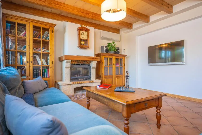 A living room with blue seating, a wooden coffee table, and a fireplace.