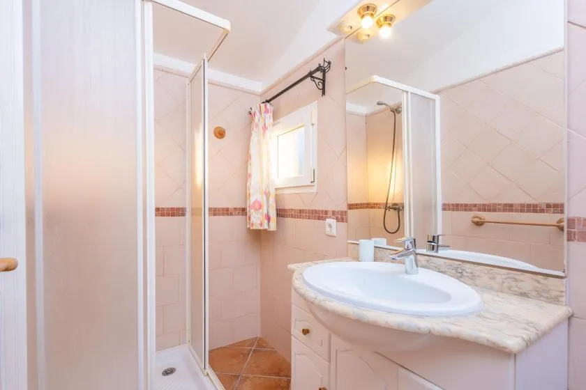 A bathroom with a sink, mirror, and glass shower.