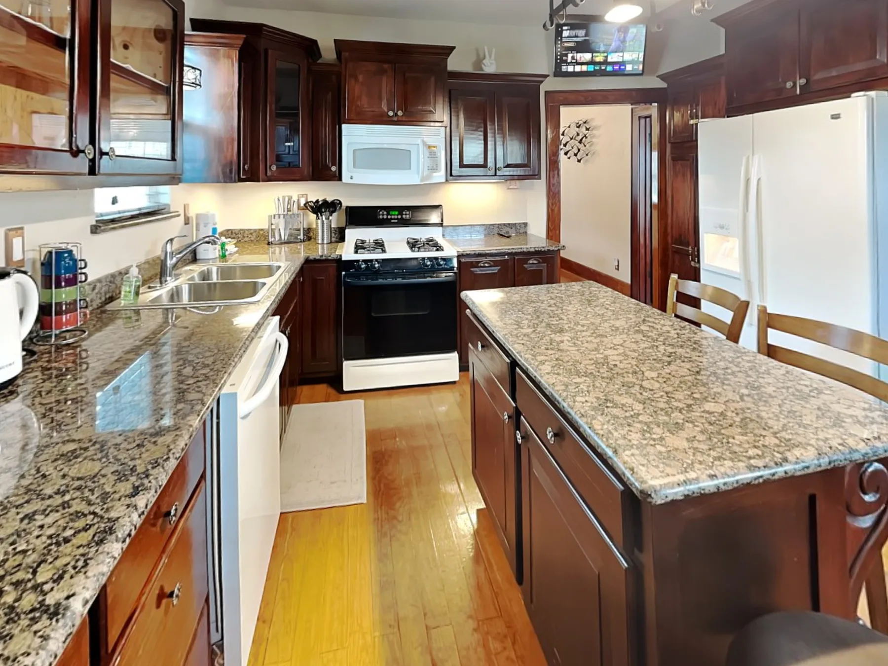 Una cocina con gabinetes de madera oscura, una isla central y electrodomésticos de acero inoxidable.