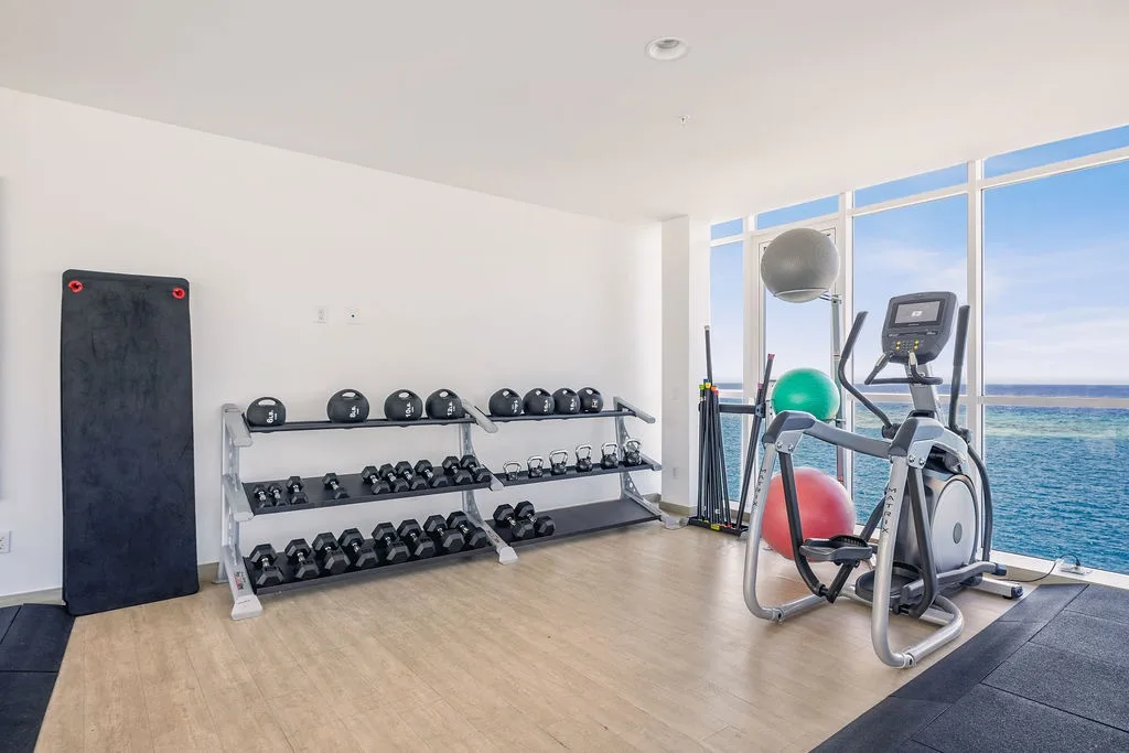 Stay energized with a fully equipped workout space featuring free weights, cardio equipment, and an inspiring ocean view to motivate your fitness routine.