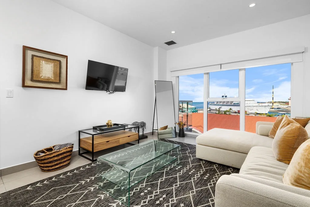 Relax in your bright, modern living room with coastal charm and unwind with sea views framed by large windows. Sink into plush seating as ocean breezes invite daydreams.