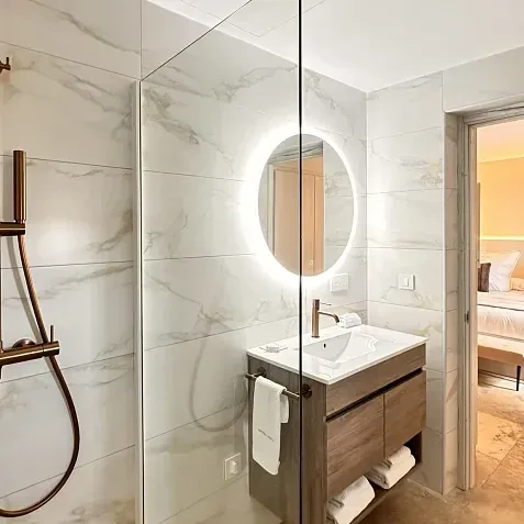 Habitación doble con cama matrimonial, ducha y lavabo