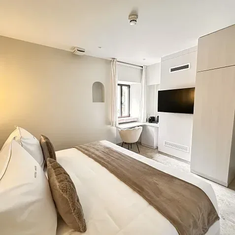 Habitación doble con cama matrimonial, televisión y ventana