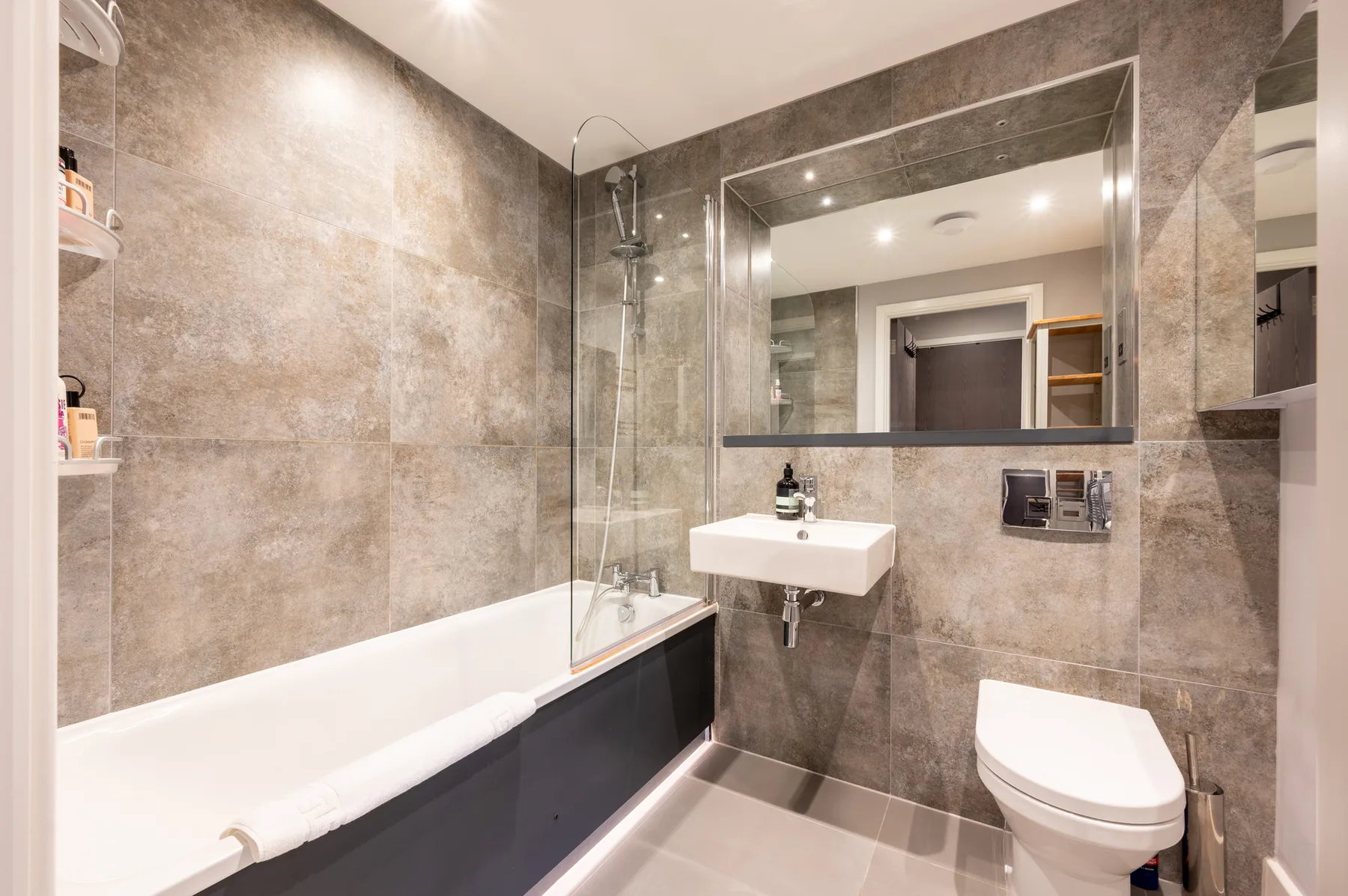Un baño alicatado con bañera, lavabo e inodoro.