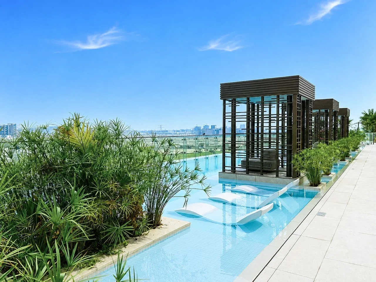 Una piscina en la azotea rodeada de vegetación y estructuras de sombra con asientos.