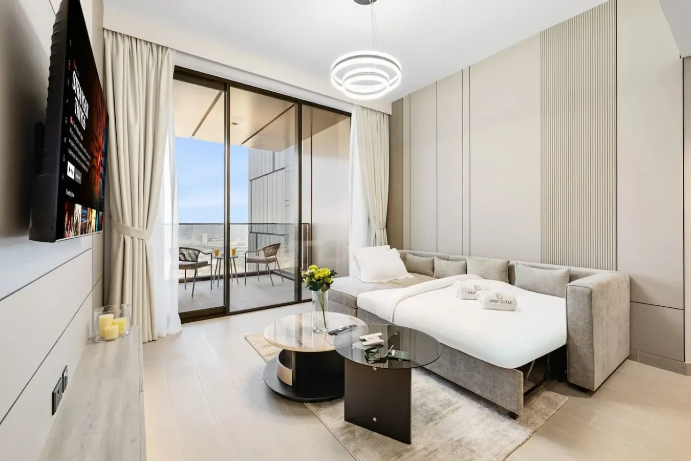 Una sala luminosa con asientos seccionales y puertas de vidrio que dan a un balcón.