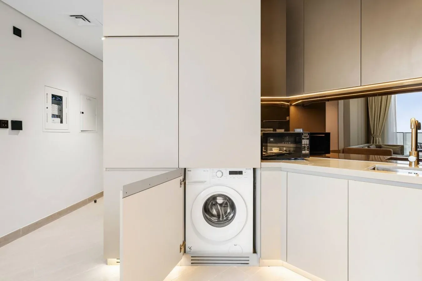 Una cocina moderna con una lavadora de carga frontal bajo la encimera.