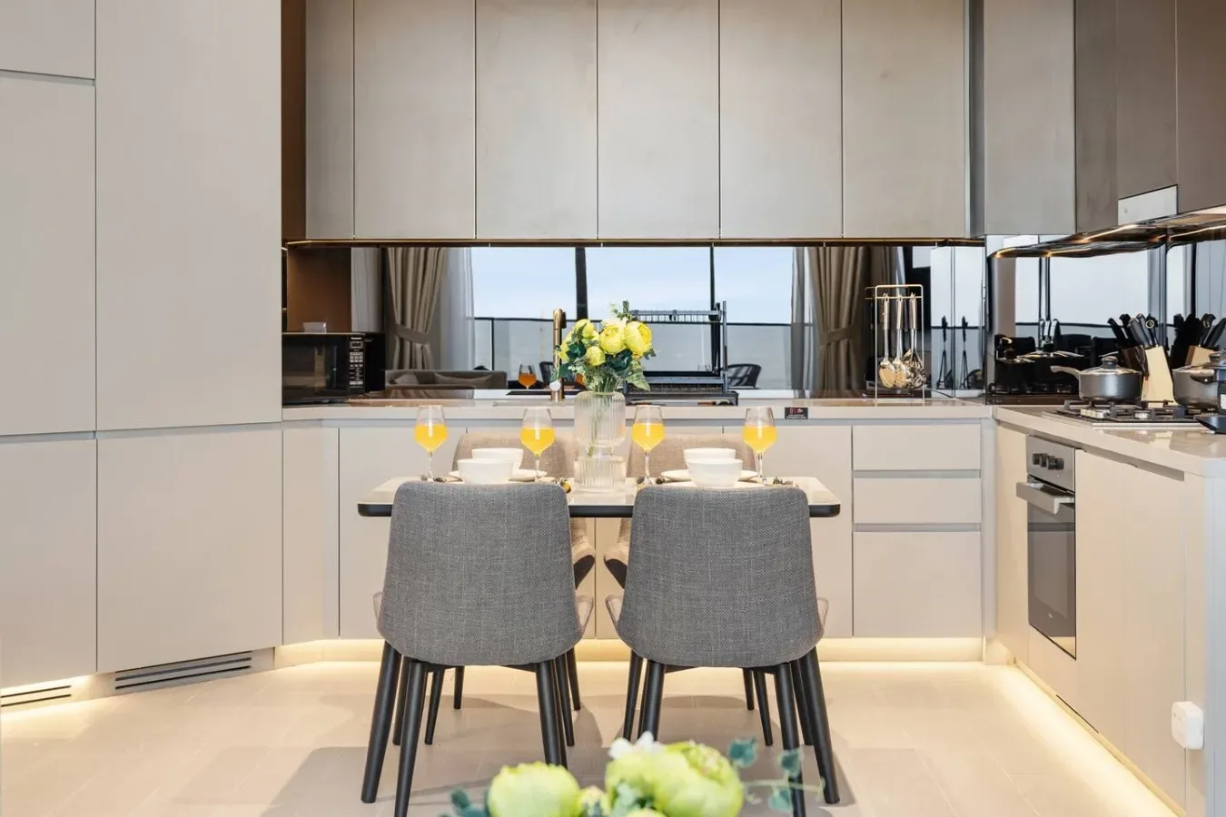 Una cocina moderna con una mesa de comedor y asientos tapizados en gris.