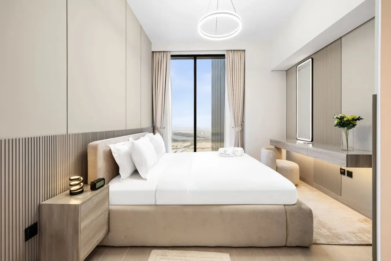Un dormitorio luminoso con una cama grande y una ventana de suelo a techo.