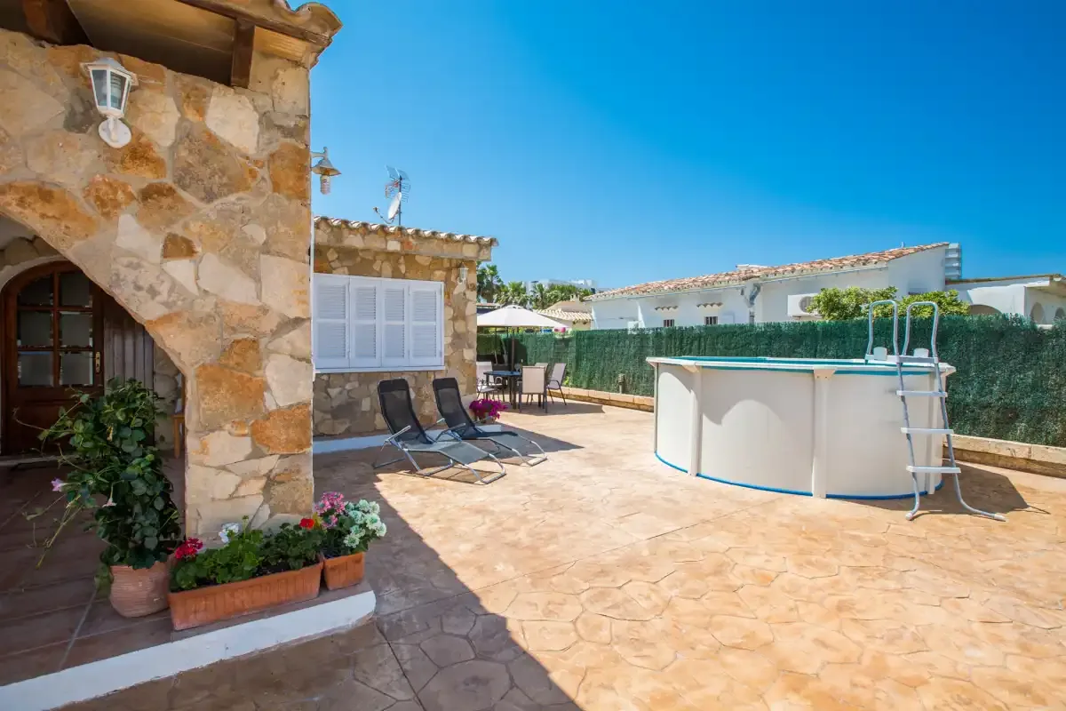A sunny outdoor patio with a small above-ground pool and seating.