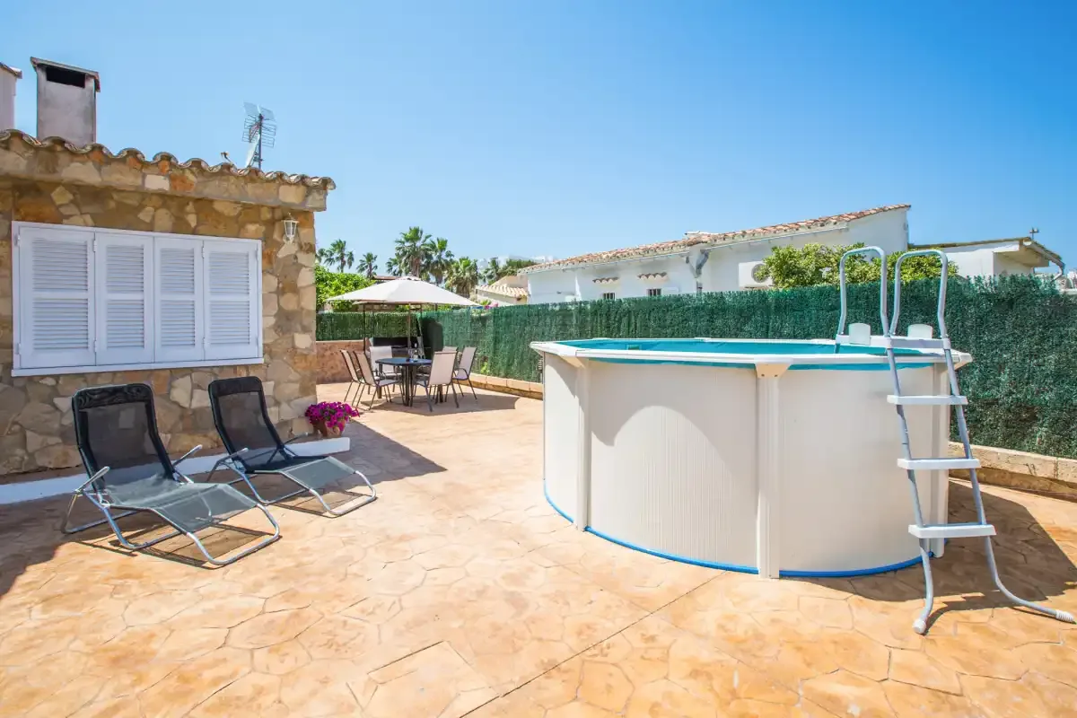 A sunny patio with an above-ground pool and outdoor seating.