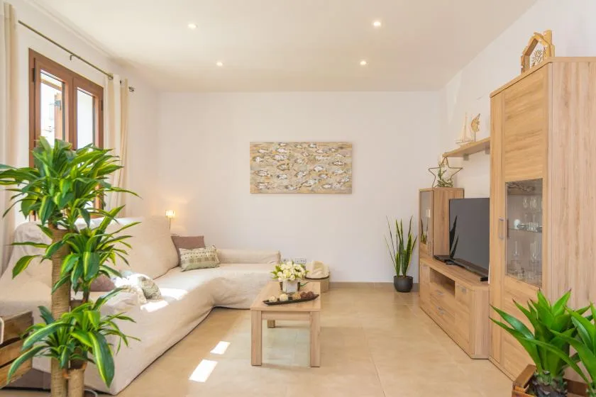 A bright living room with seating, a coffee table, and a television.