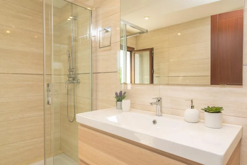 A bright bathroom with a glass shower and a wide sink vanity.