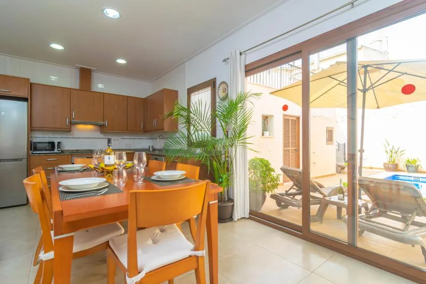 A dining area beside a kitchen opens through sliding glass doors to a sunny patio.